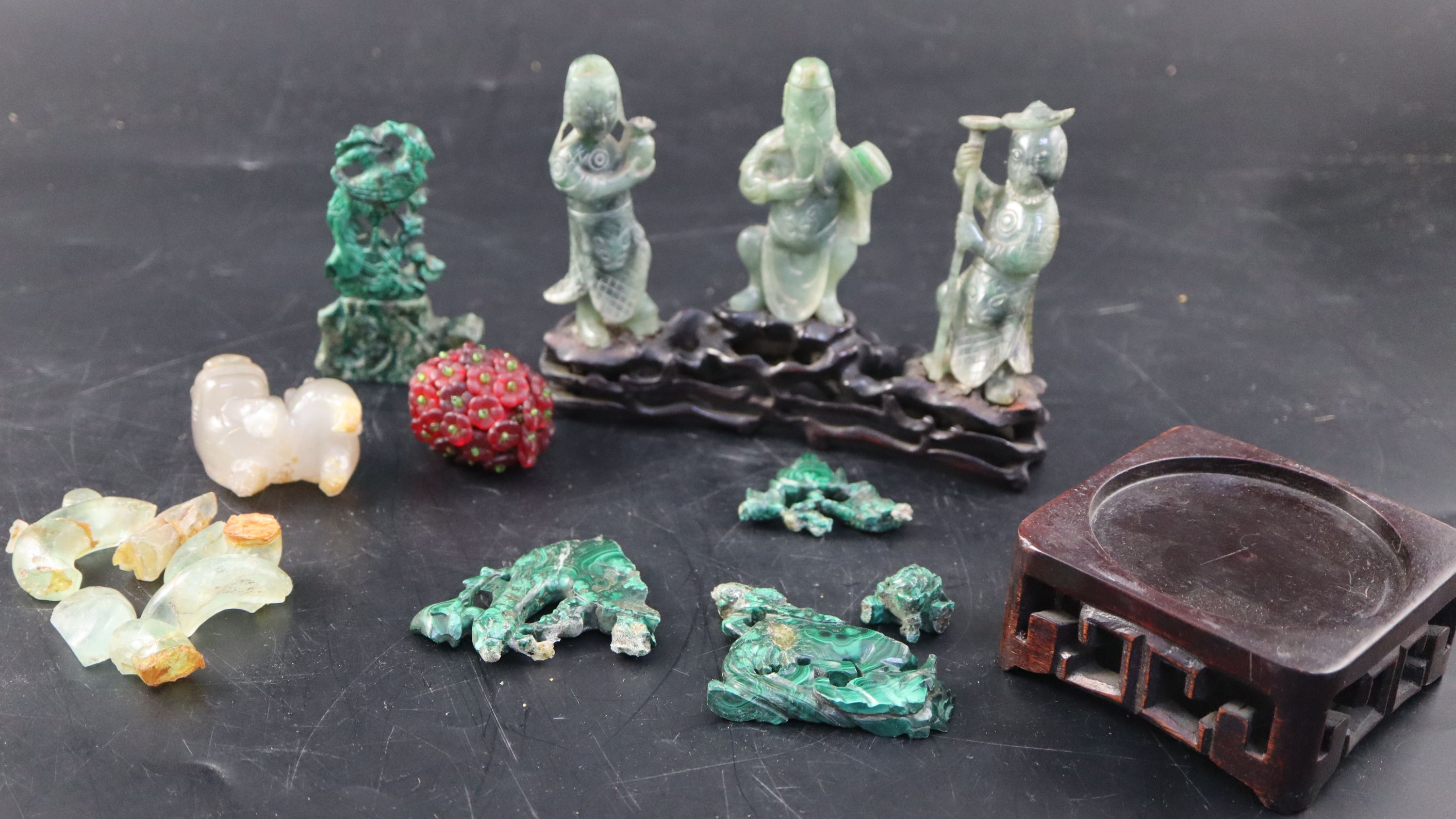 A set of three Chinese carved hardstone figures of immortals, stand; shi shi, malachite fragments etc.